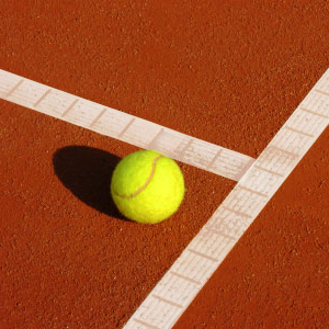 Tennisball auf rotem Tennisplatz